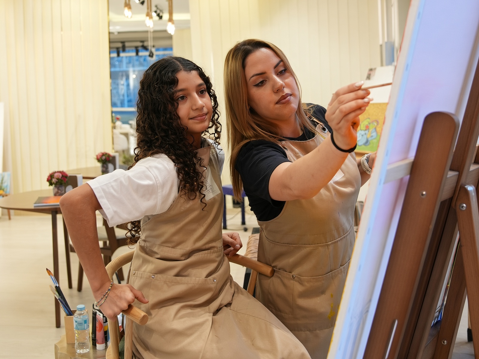 فتاة ومشاركة في تجربة الرسم على لوحة في مركز أيادي